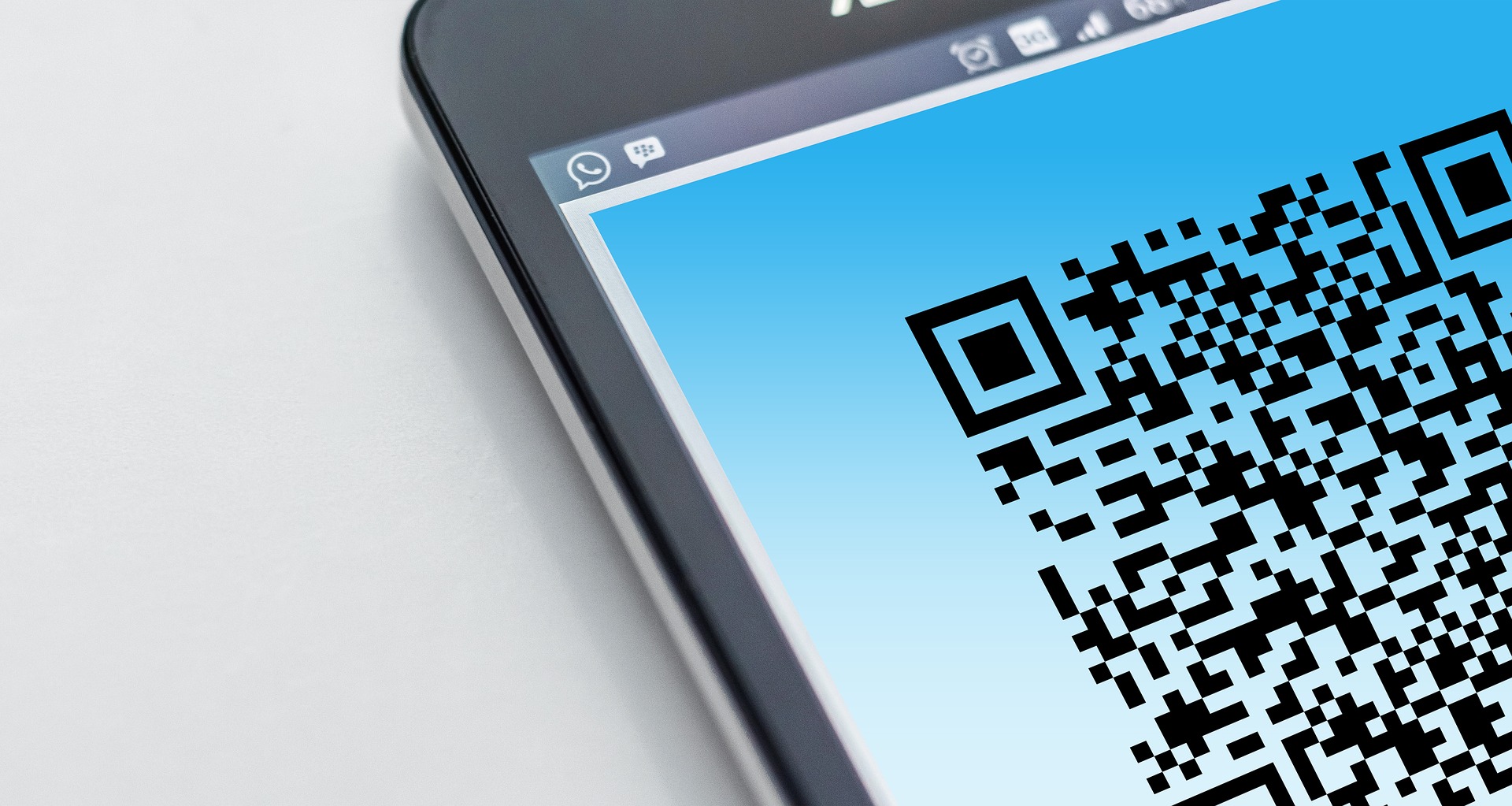 Zdjęcie przedstawia telefon z wyświetlonym kodem QR.